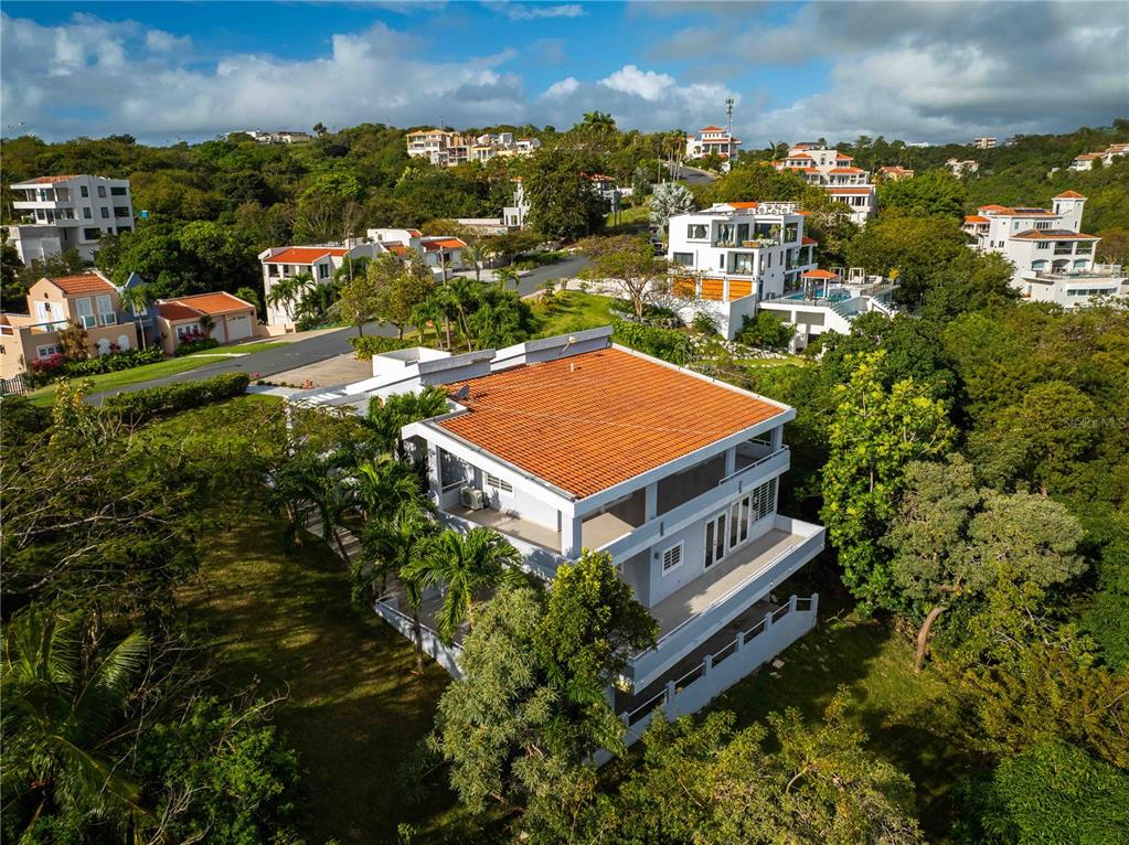An aerial view shows a multi-story house with a terracotta tile roof amidst trees — 15 PORT ROAD, HUMACAO, PR