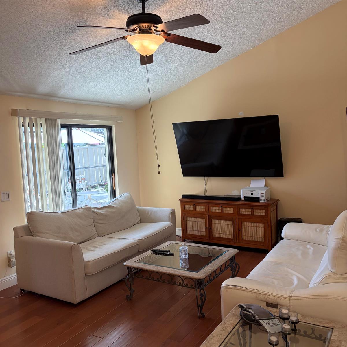 A living room features a ceiling fan, a wall-mounted television, two sofas, and hardwood floors — 5654 Golden Eagle Circle, Palm Beach Gardens FL 33418, PALM BEACH GARDENS, FL