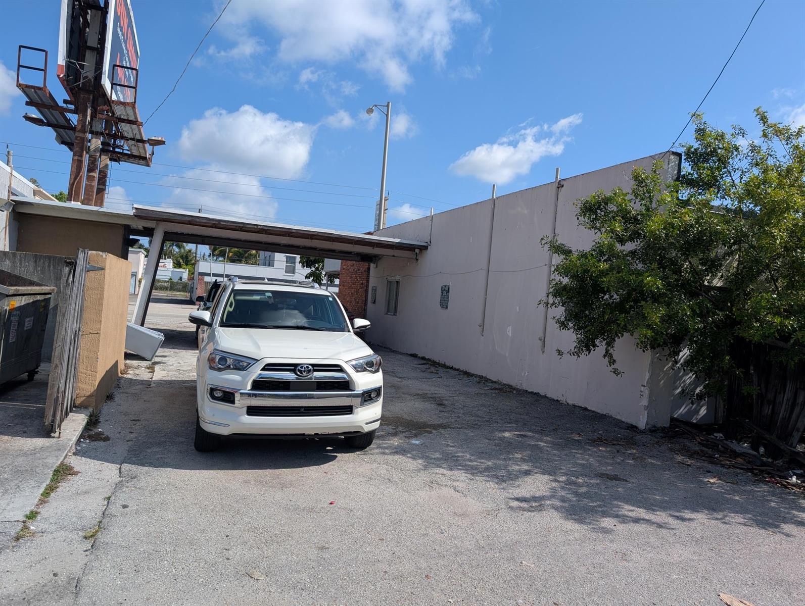 A white Toyota SUV is parked on a gravel lot next to a beige building — 734 Belvedere Road, West Palm Beach FL 33405, WEST PALM BEACH, FL