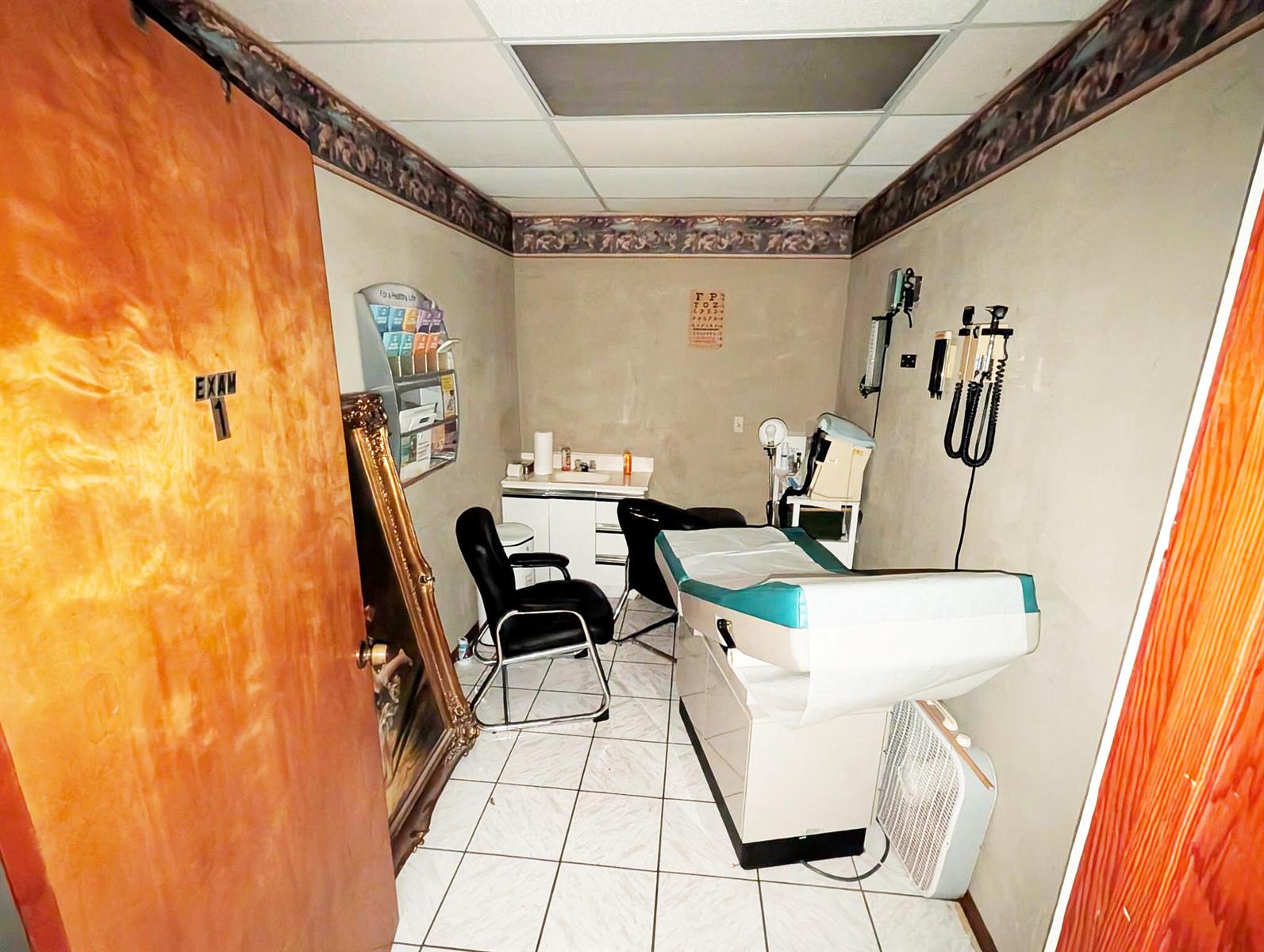A medical exam room features a treatment table, two chairs, a sink, and wall-mounted equipment — 734 Belvedere Road, West Palm Beach FL 33405, WEST PALM BEACH, FL