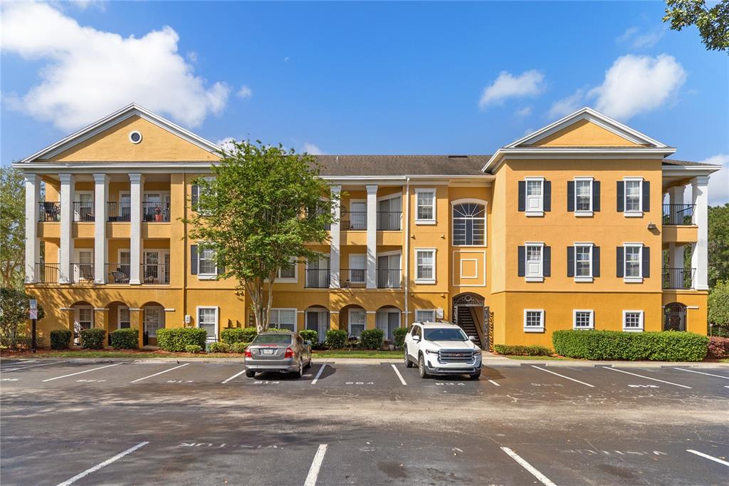 A covered patio features yellow walls, a decorative metal gate, and multiple glass-paned doors — 3599 CONROY ROAD UNIT 915, ORLANDO, FL