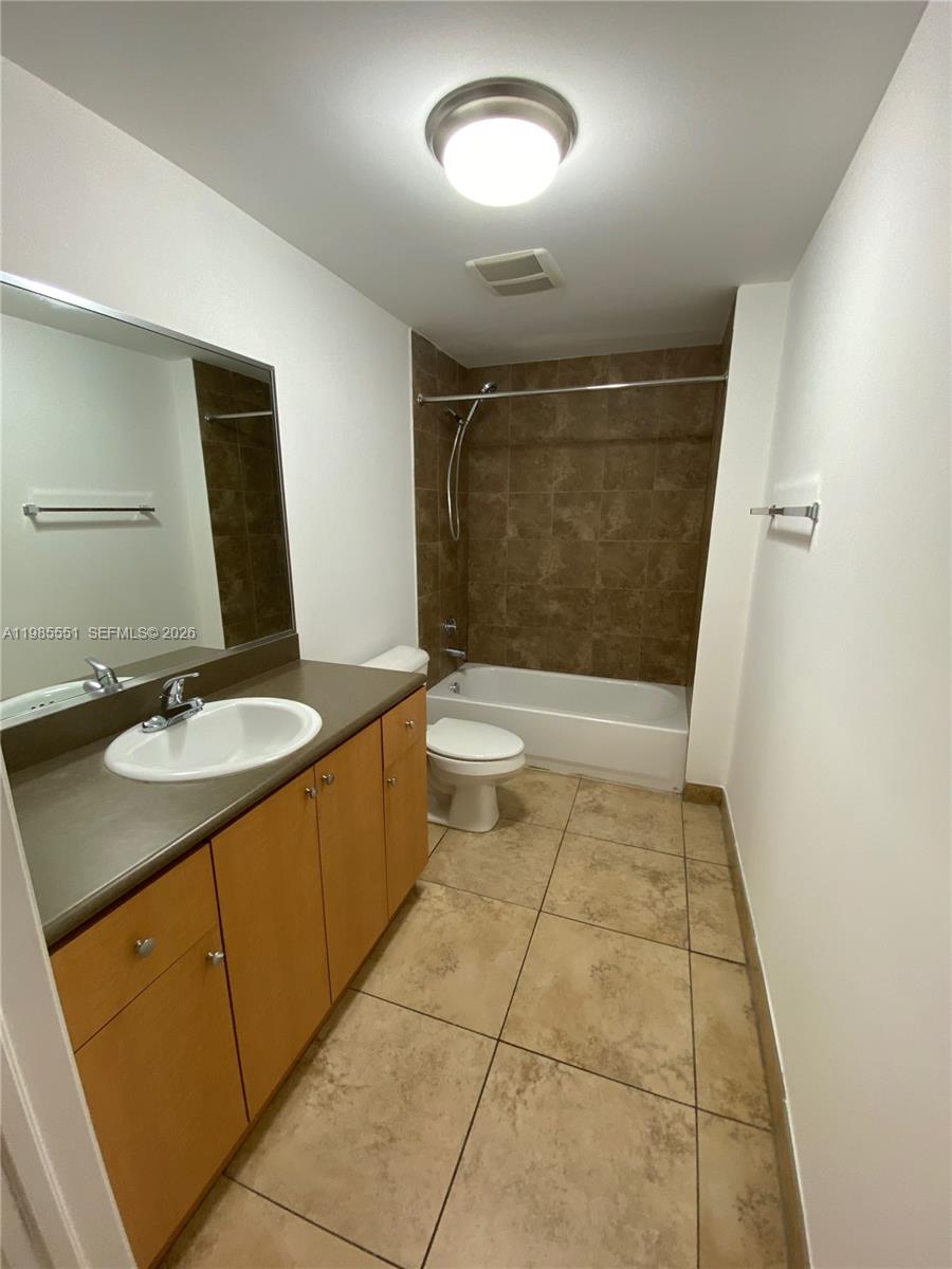 A bathroom features a vanity with a brown countertop, a toilet, and a tiled tub-shower — 435 SW 12th Ave # 605, Miami FL 33130, MIAMI, FL