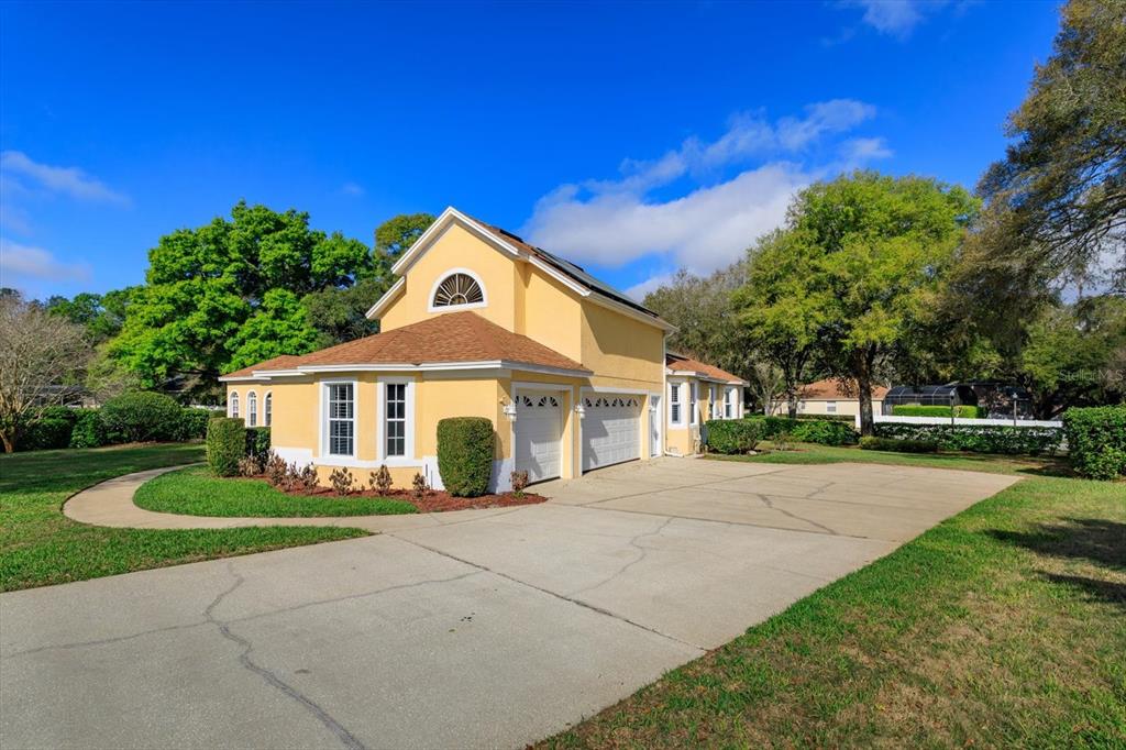A yellow two-story house with a brown roof and a large concrete driveway — 3712 CLYDEBANK COURT, APOPKA, FL
