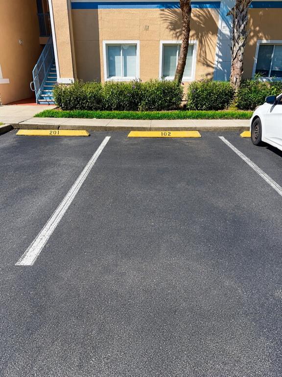 A two-story apartment building with a tan exterior, tiled roof, and a parking lot — 13226 GALICIA STREET UNIT 102, ORLANDO, FL