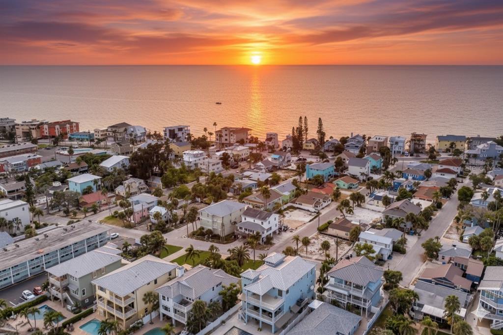 An aerial view of a coastal neighborhood with houses near the ocean at sunset — 134 86TH TERRACE, TREASURE ISLAND, FL