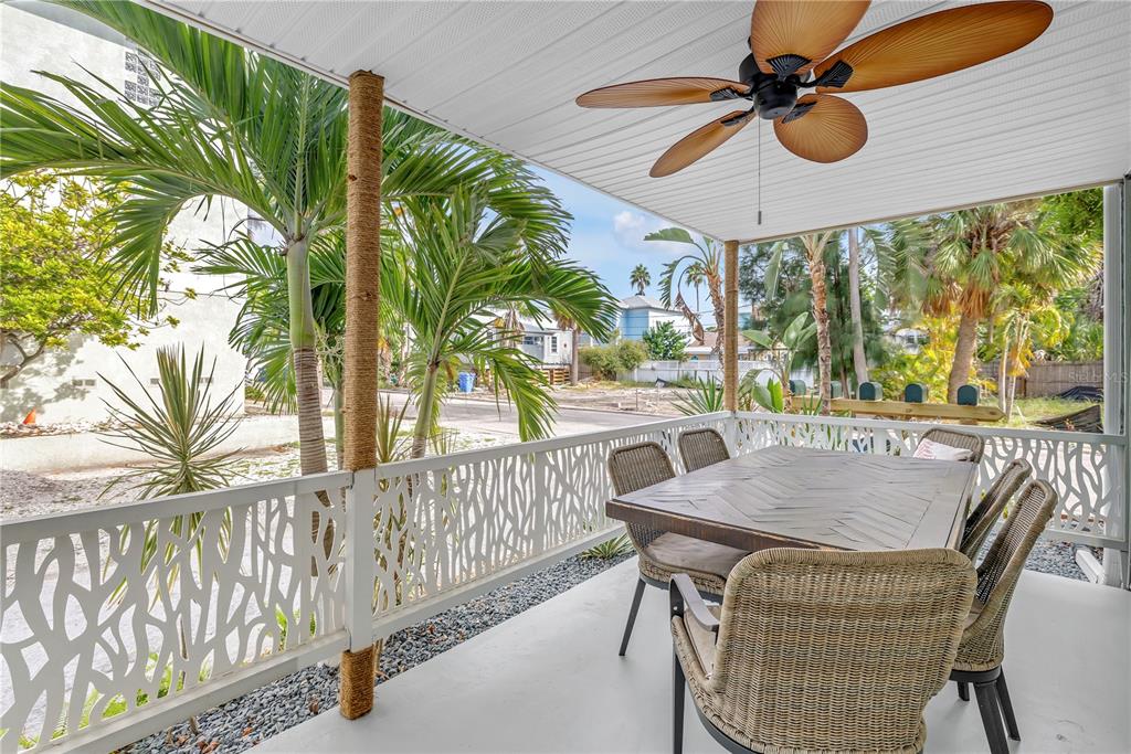 A covered outdoor patio features a dining table, wicker chairs, and a ceiling fan — 134 86TH TERRACE, TREASURE ISLAND, FL