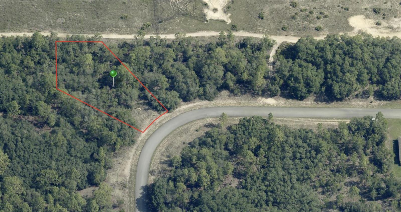 An aerial view shows a wooded, irregularly shaped vacant lot outlined in red near a road — 3051 W Redgate Drive, FL 34433, FL