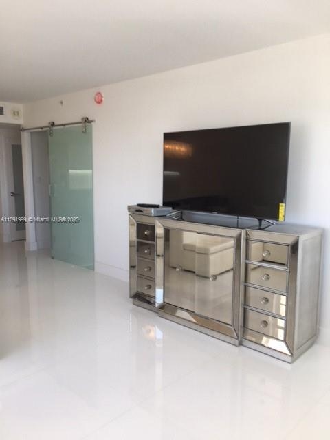 A modern living room features a mirrored media console supporting a flat-screen television — 100 LINCOLN RD # 711, Miami Beach FL 33139, MIAMI BEACH, FL