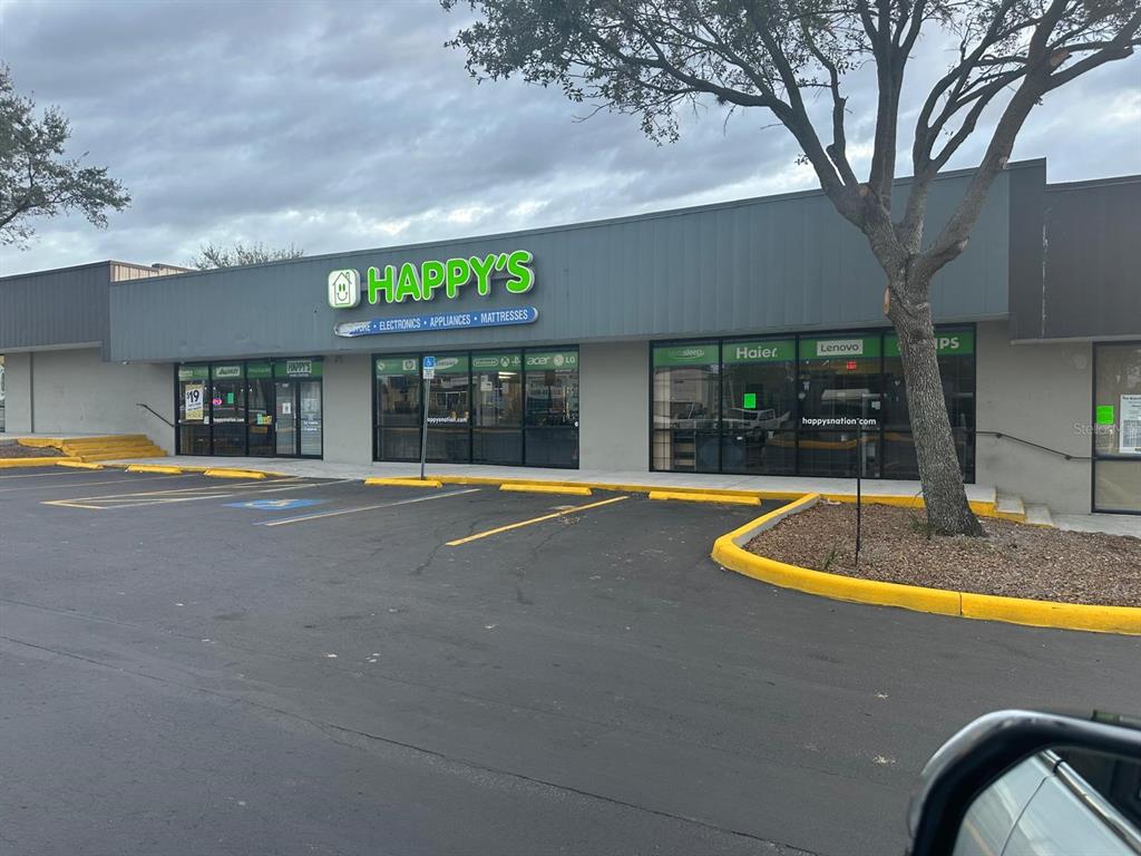 A storefront for Happy's featuring electronics, appliances, and mattresses with a parking lot in front — 1727 E BUSCH BOULEVARD, TAMPA, FL