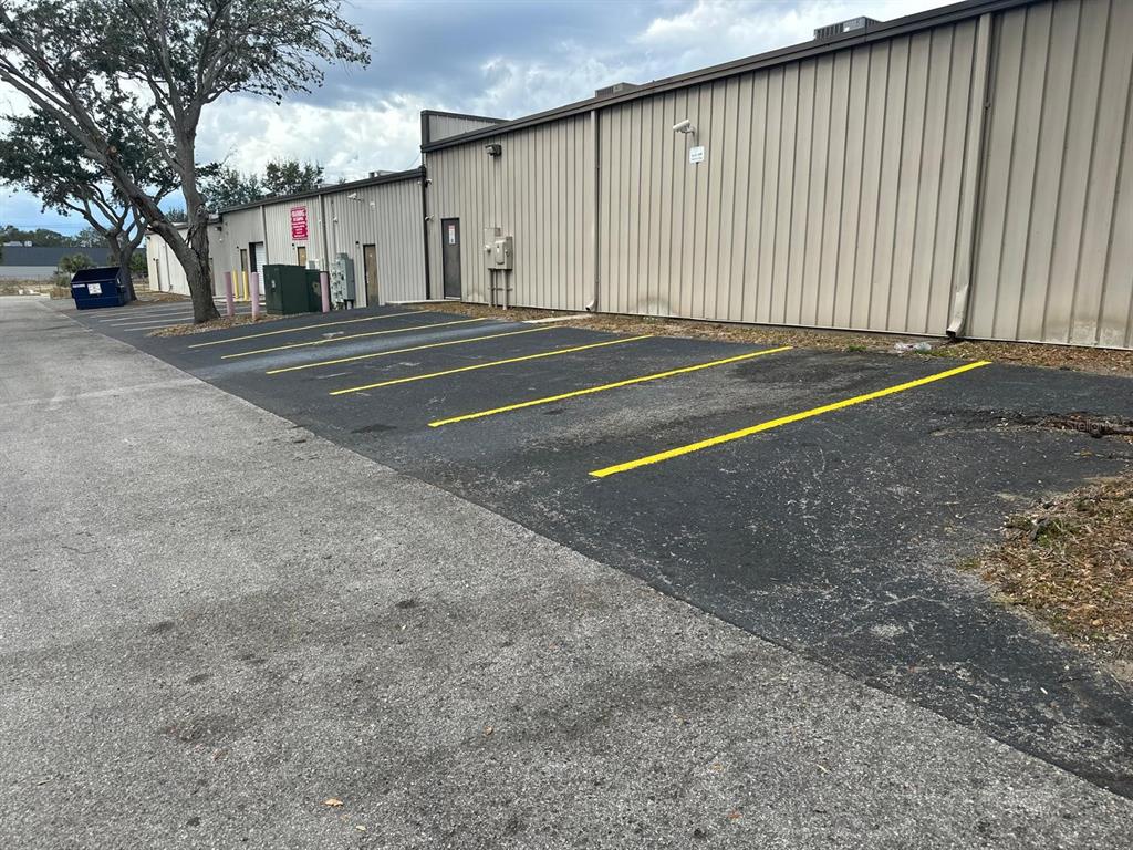 An exterior view of a commercial building with a paved parking lot and yellow lines — 1727 E BUSCH BOULEVARD, TAMPA, FL