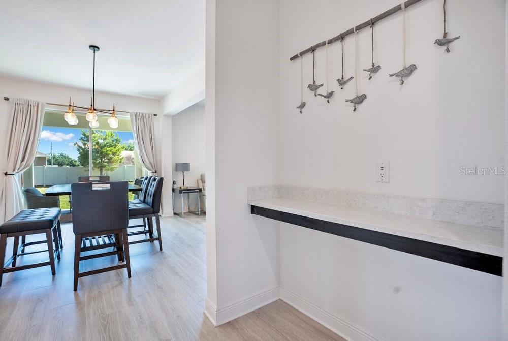 A kitchen features a black induction cooktop, white hexagonal tile backsplash, and dark cabinetry — 5063 HATCHINEHA COURT, ST CLOUD, FL