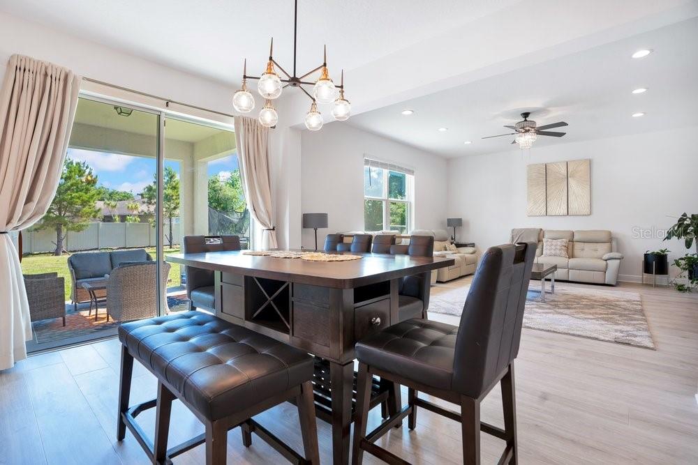 A modern kitchen features black cabinets, white countertops, a farmhouse sink, and a tile backsplash — 5063 HATCHINEHA COURT, ST CLOUD, FL