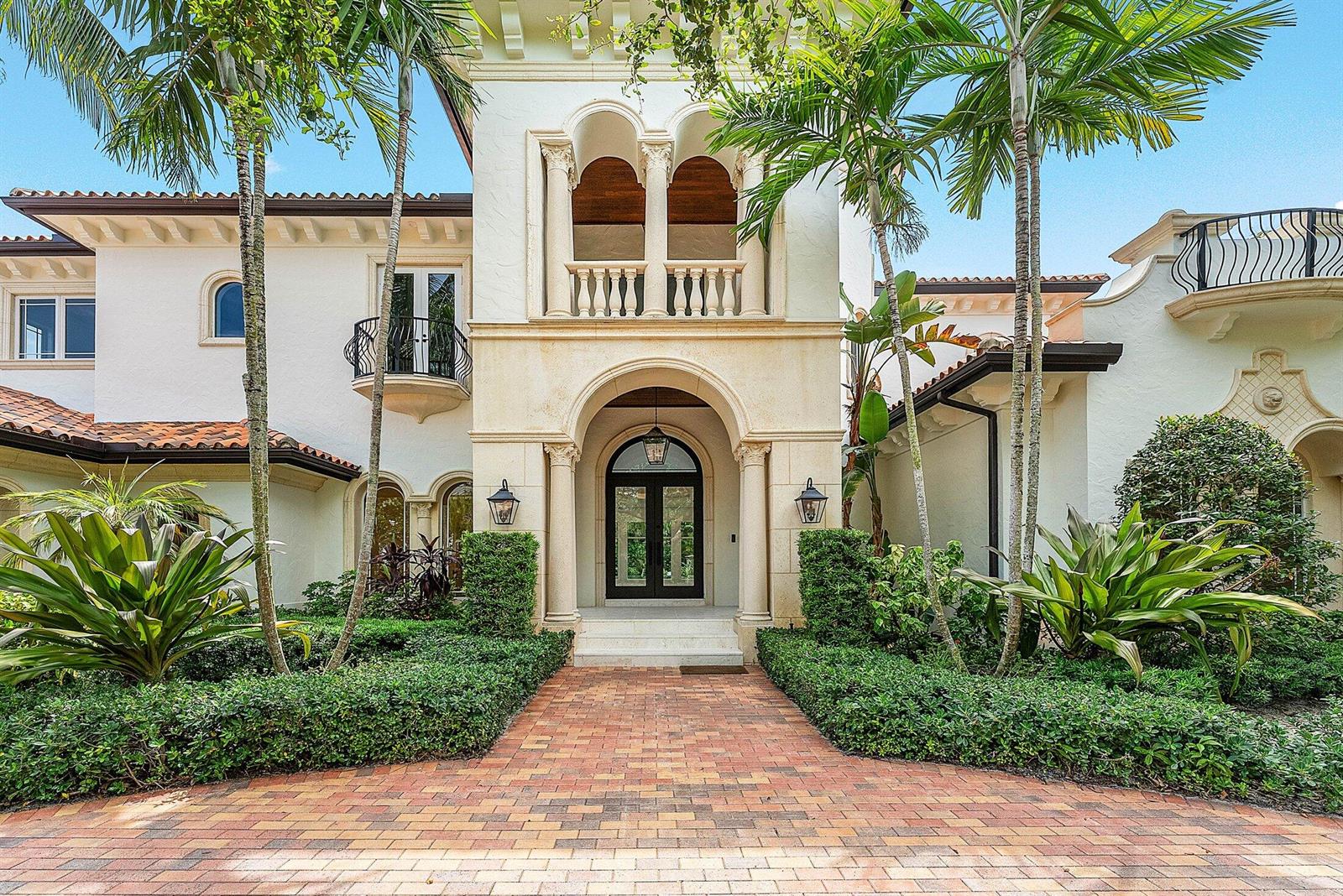 A brick walkway leads to the arched stone entrance of a Mediterranean-style home with palms — 2002 NW 4th Avenue, Delray Beach FL 33444, DELRAY BEACH, FL