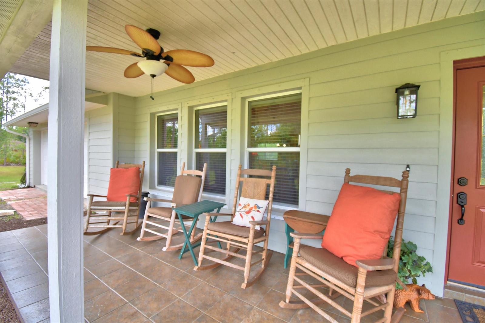 A covered porch features four wooden rocking chairs with cushions and a ceiling fan — 32801 Hwy 441 N # 36, Okeechobee FL 34972, OKEECHOBEE, FL