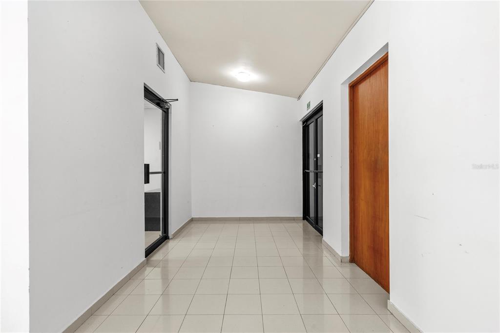 A bright hallway features white walls, light-colored floor tiles, and three doorways — 141 O'NEILL, SAN JUAN, PR