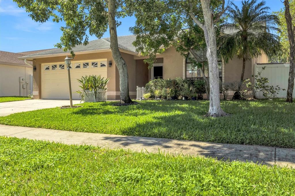 A single-story house with a beige exterior, a two-car garage, and a front yard — 3631 102ND PLACE N, CLEARWATER, FL