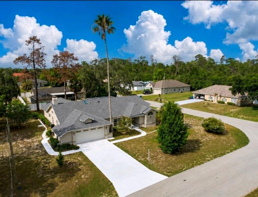 An aerial view shows a single-story house with a gray roof and a concrete driveway — 12380 TANSBORO STREET, SPRING HILL, FL