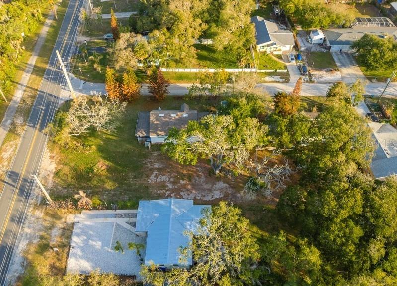 An aerial view shows two houses surrounded by trees and a road on the left — 2803 SAXON DRIVE, NEW SMYRNA BEACH, FL