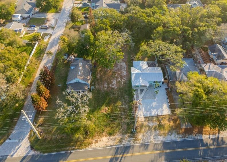 An aerial view shows two houses separated by a vacant lot along a paved road — 2803 SAXON DRIVE, NEW SMYRNA BEACH, FL