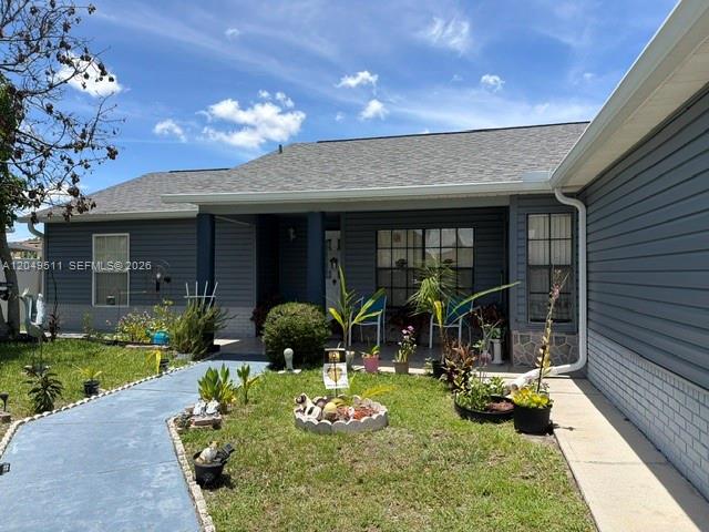 A blue walkway leads to the front entrance of a gray house with a lawn — 263 Cranbrook Dr, Kissimmee FL 34758, KISSIMMEE, FL