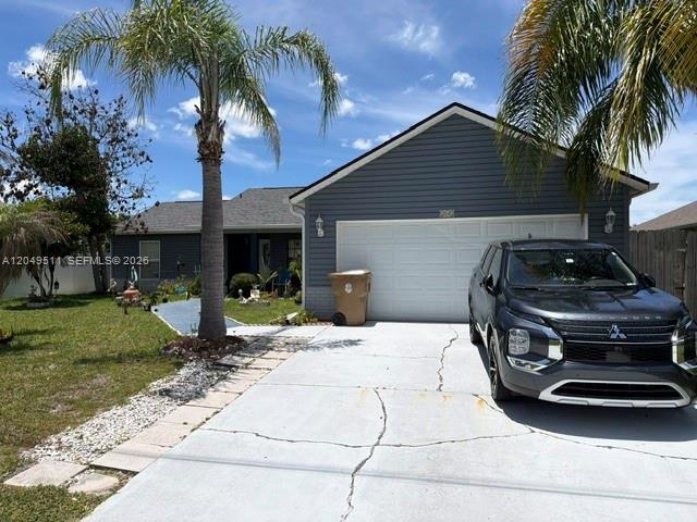 A gray house with a two-car garage and a driveway sits under a blue sky — 263 Cranbrook Dr, Kissimmee FL 34758, KISSIMMEE, FL