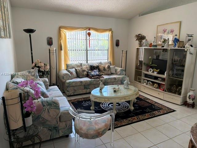A living room features floral sofas, a glass coffee table, and a large display cabinet — 263 Cranbrook Dr, Kissimmee FL 34758, KISSIMMEE, FL