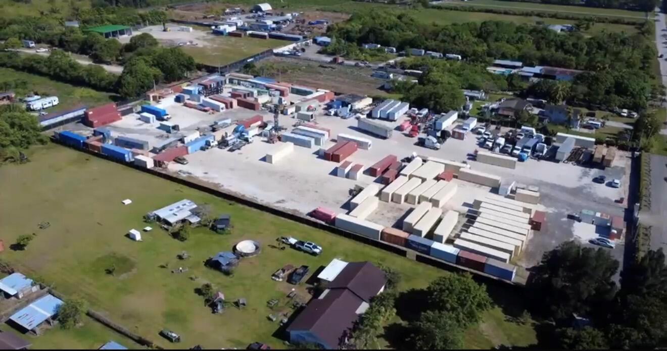 An aerial view shows a large industrial storage yard filled with numerous shipping containers and trucks — 12485 SW 197th Avenue, Miami FL 33196, MIAMI, FL
