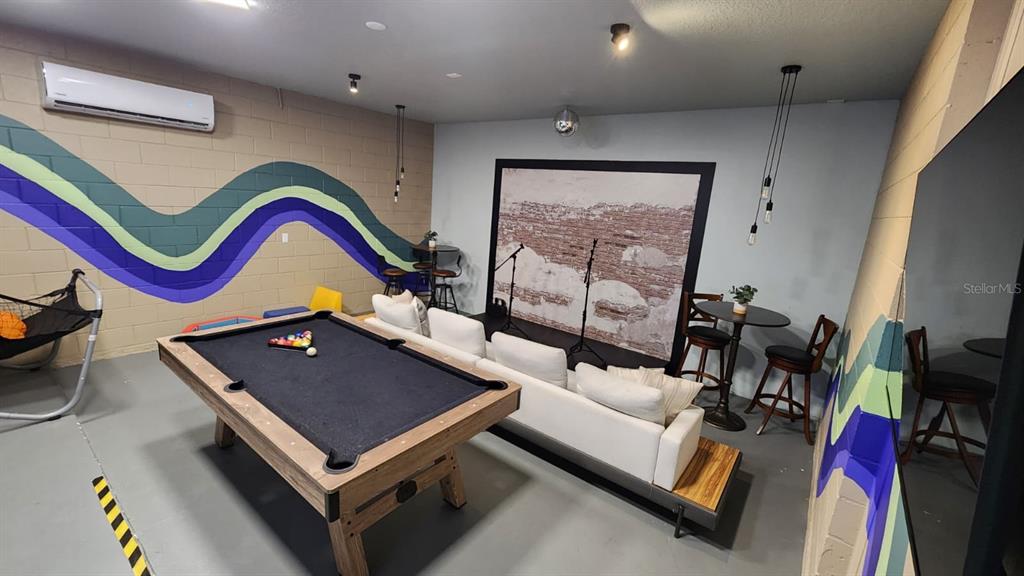 A game room features a pool table, a white sofa, and a small stage area — 221 BALLO DRIVE, KISSIMMEE, FL