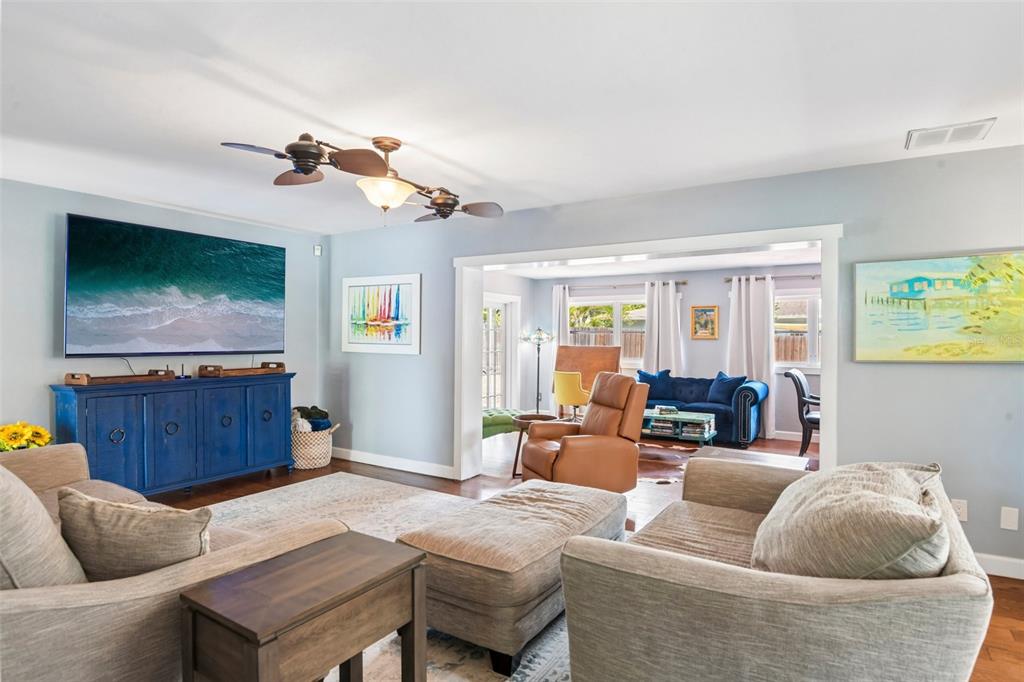 A living room with light blue walls, a blue media console, and a tan sectional — 992 HILLWOOD DRIVE, DUNEDIN, FL