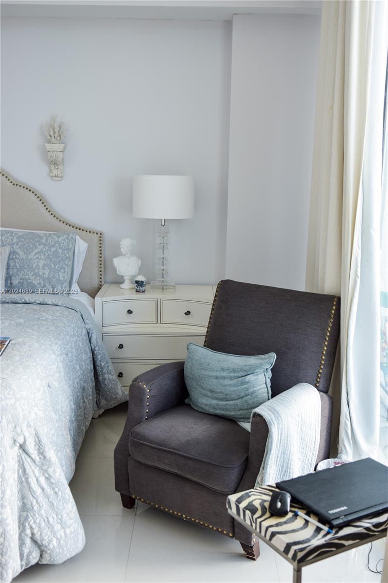 A bedroom features a bed, a nightstand with a lamp, and a dark armchair — 3180 SW 22nd Ter, Miami FL 33145, MIAMI, FL