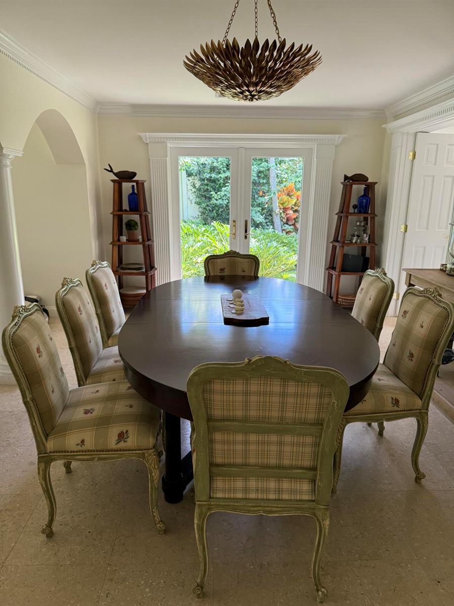 A dining room features an oval wooden table, plaid chairs, and a unique gold chandelier — 222 Miraflores Drive, Palm Beach FL 33480, PALM BEACH, FL