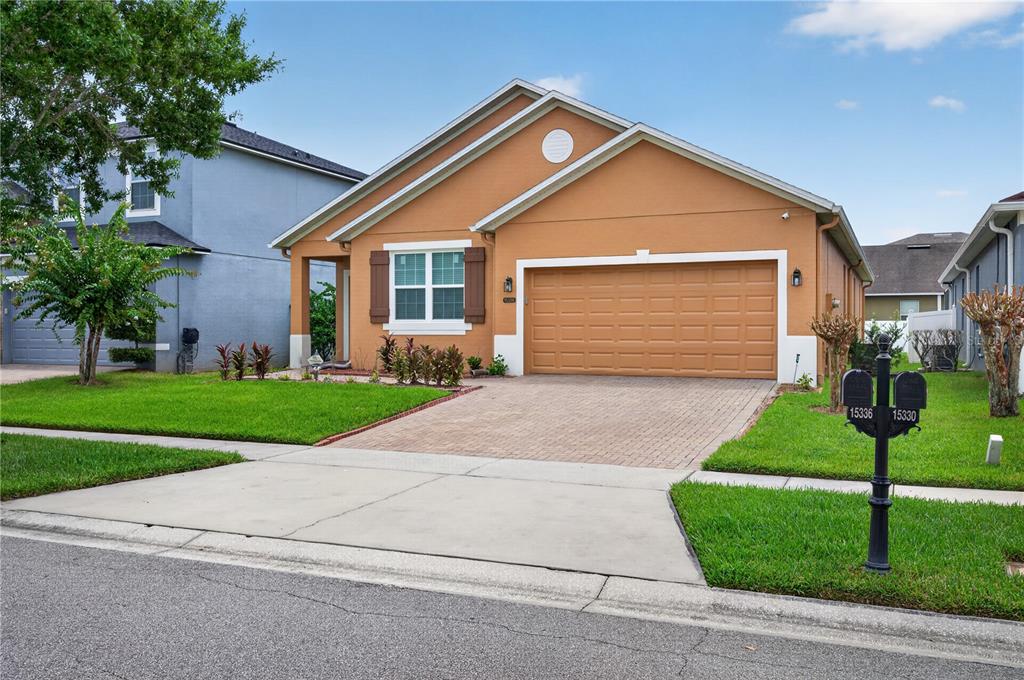 A one-story tan house with a two-car garage and a paved driveway — 15336 TREVISO STREET, ORLANDO, FL