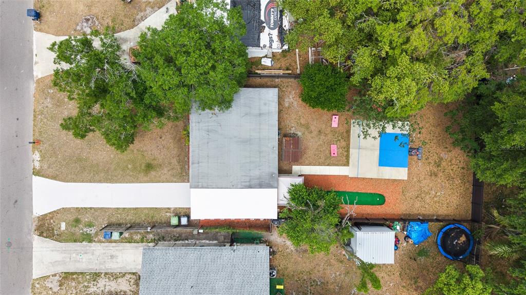 An aerial view shows a house with a flat roof, a backyard pool, and landscaping — 8707 N ASHLEY STREET, TAMPA, FL