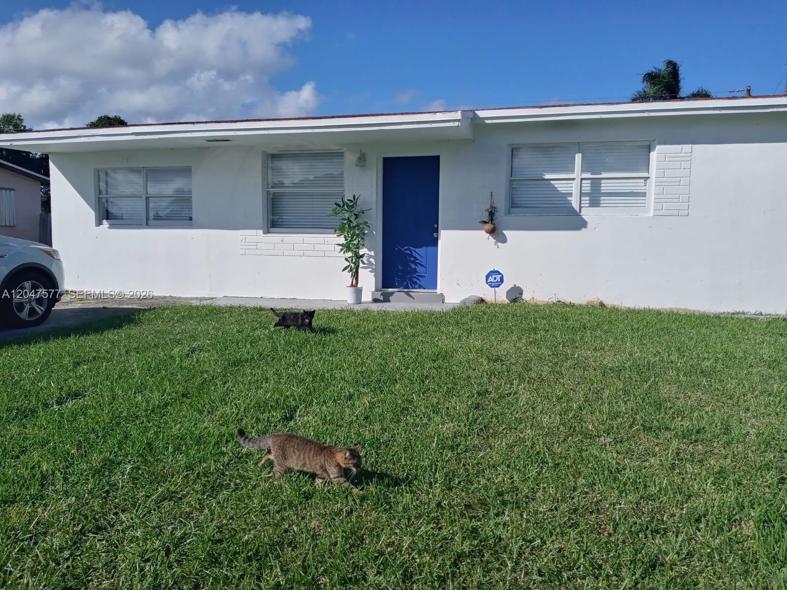 A room with white walls, light wood-look flooring, a ceiling fan, and a closed door — 10961 SW 222nd Ter, Miami FL 33170, MIAMI, FL