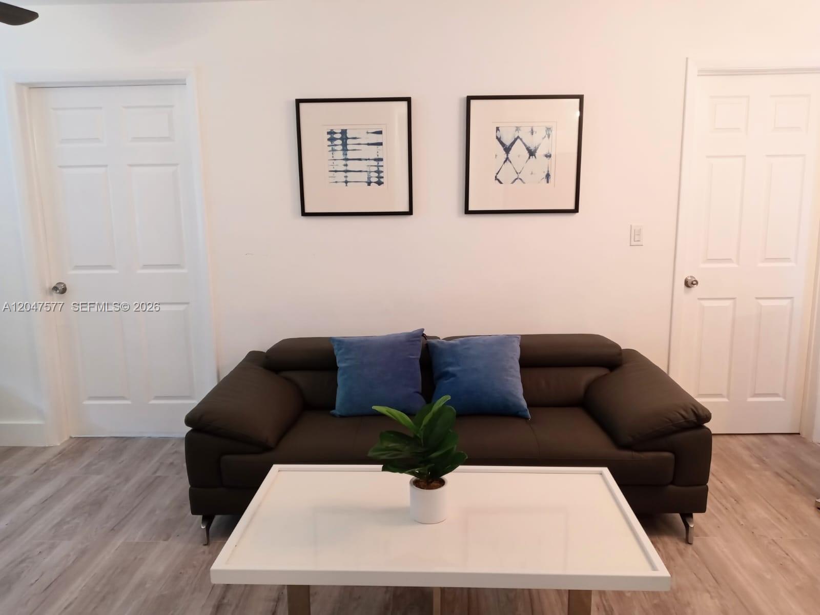 A room with white walls, light wood-look flooring, and two white six-panel doors — 10961 SW 222nd Ter, Miami FL 33170, MIAMI, FL