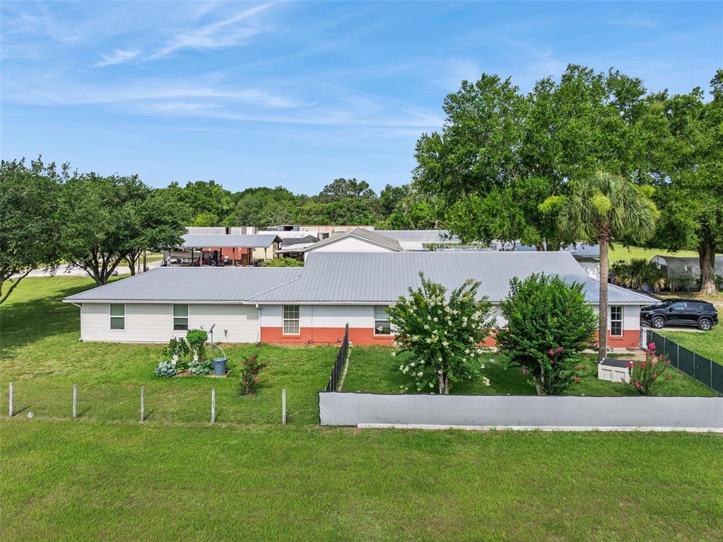 An aerial view of a single-story house with a metal roof and a fenced yard — 15000 S US HIGHWAY 441 HIGHWAY S, SUMMERFIELD, FL