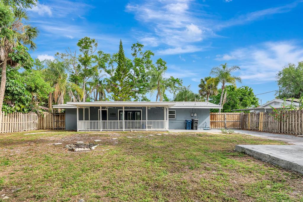 A gray house with a white-railed porch sits in a large, grassy backyard — 2510 51ST AVENUE TERRACE W, BRADENTON, FL