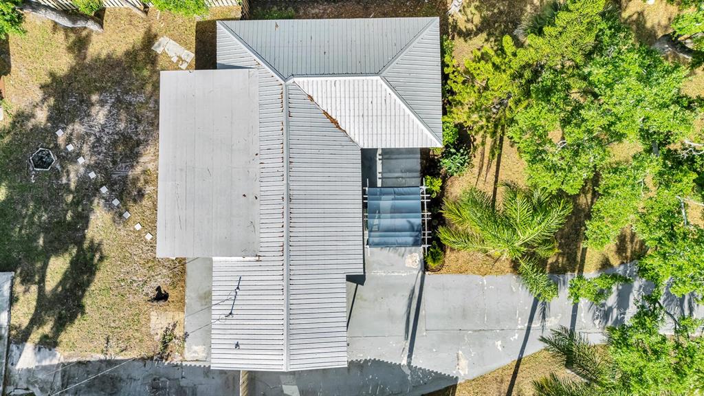 An aerial view shows a house with a metal roof, a driveway, and surrounding trees — 2510 51ST AVENUE TERRACE W, BRADENTON, FL