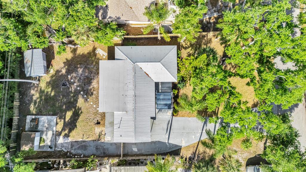 An aerial view shows a house with a metal roof surrounded by trees and landscaping — 2510 51ST AVENUE TERRACE W, BRADENTON, FL