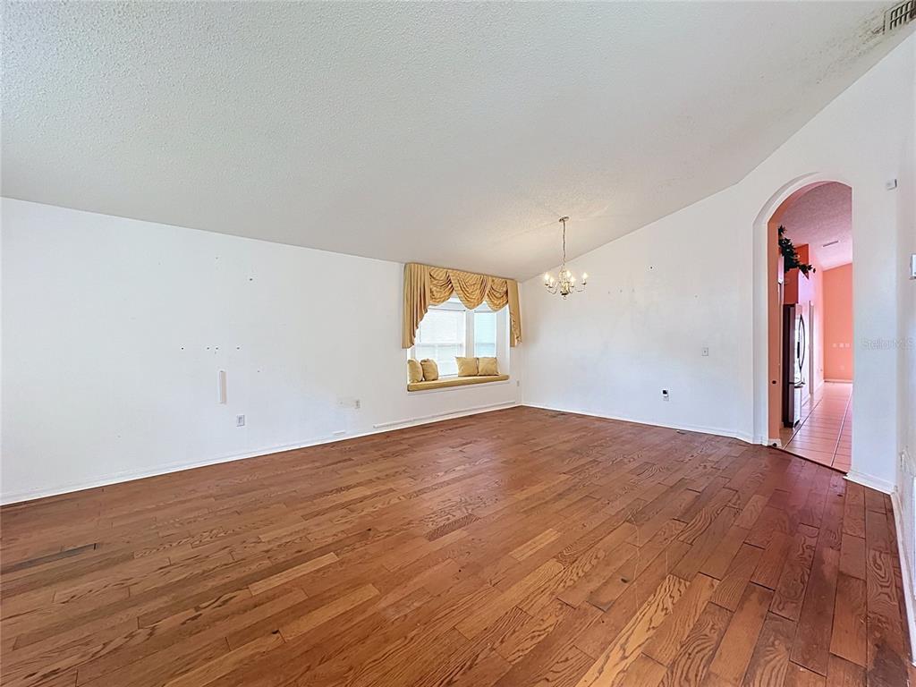 An empty room with hardwood floors, a window seat, and a chandelier — 3122 MONTSERRAT WAY, HAINES CITY, FL