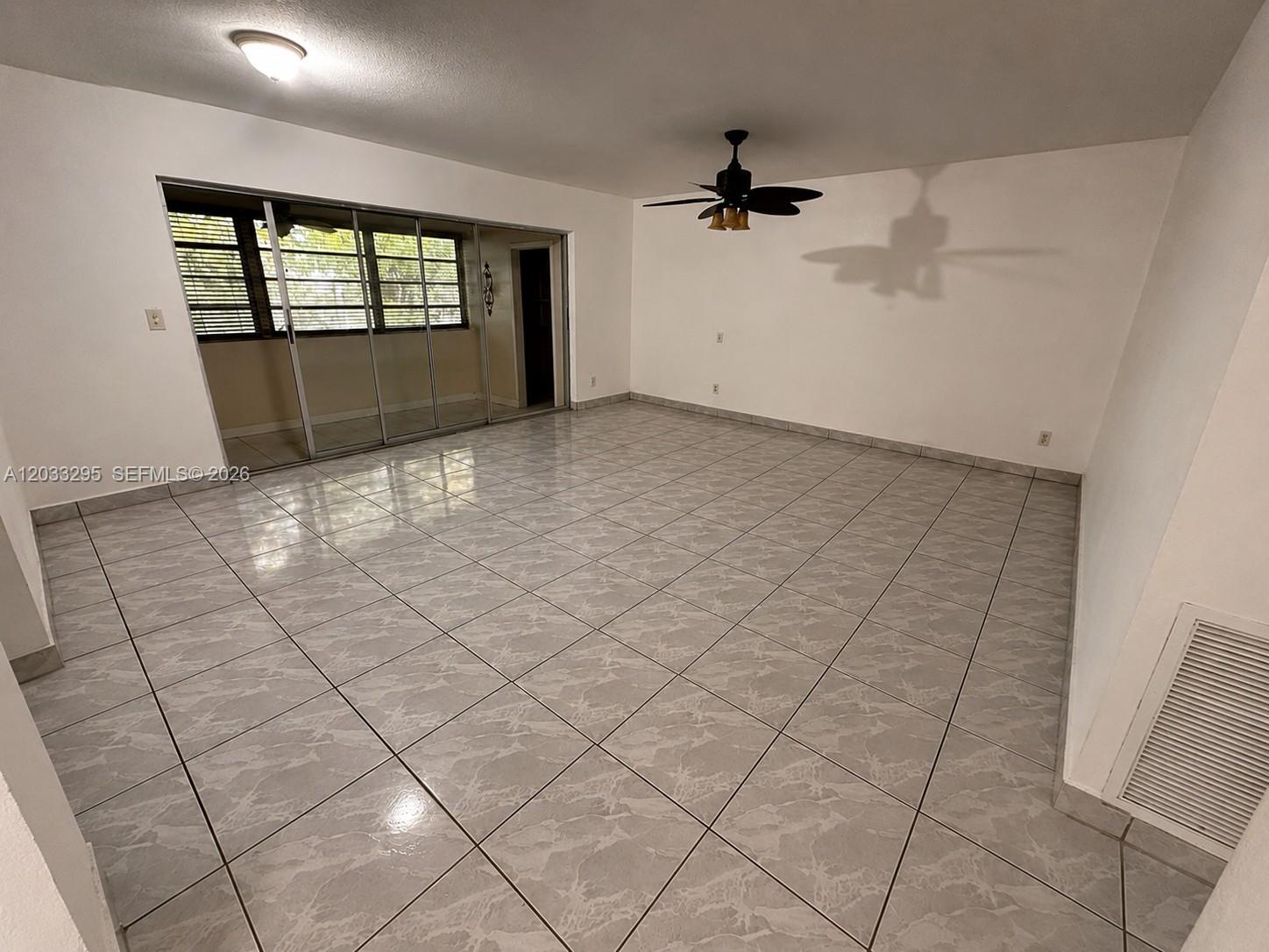 An empty living room features light gray marble-patterned tile flooring and a ceiling fan — 17215 SW 112 CT, Miami FL 33157, MIAMI, FL