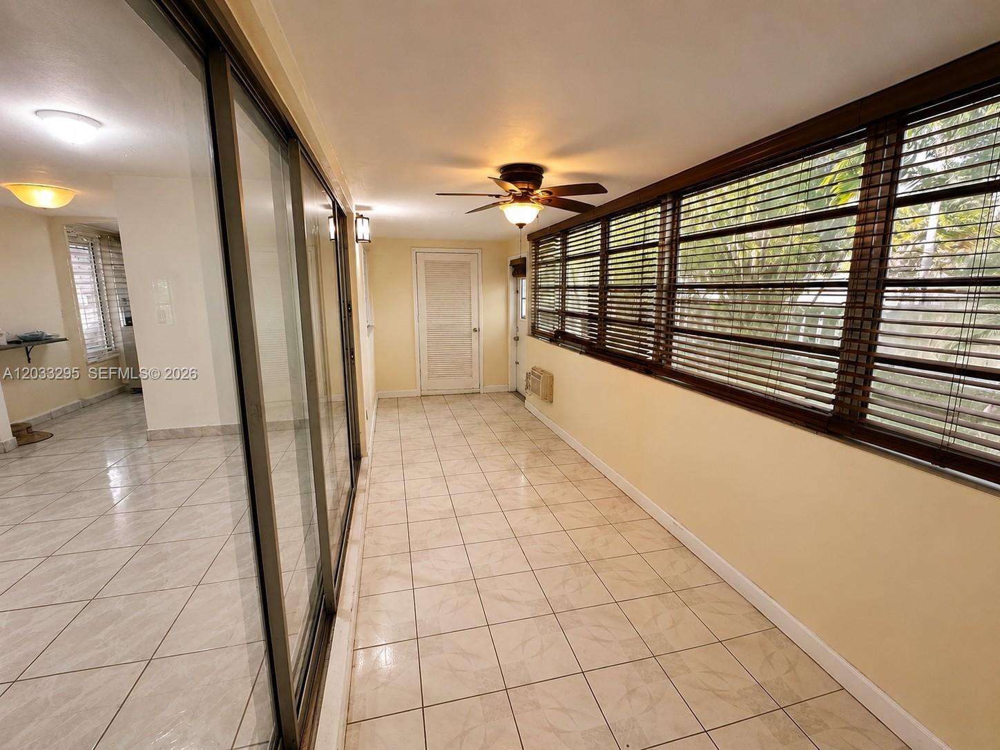 A sunroom features tiled flooring, a ceiling fan, and large windows with wooden blinds — 17215 SW 112 CT, Miami FL 33157, MIAMI, FL