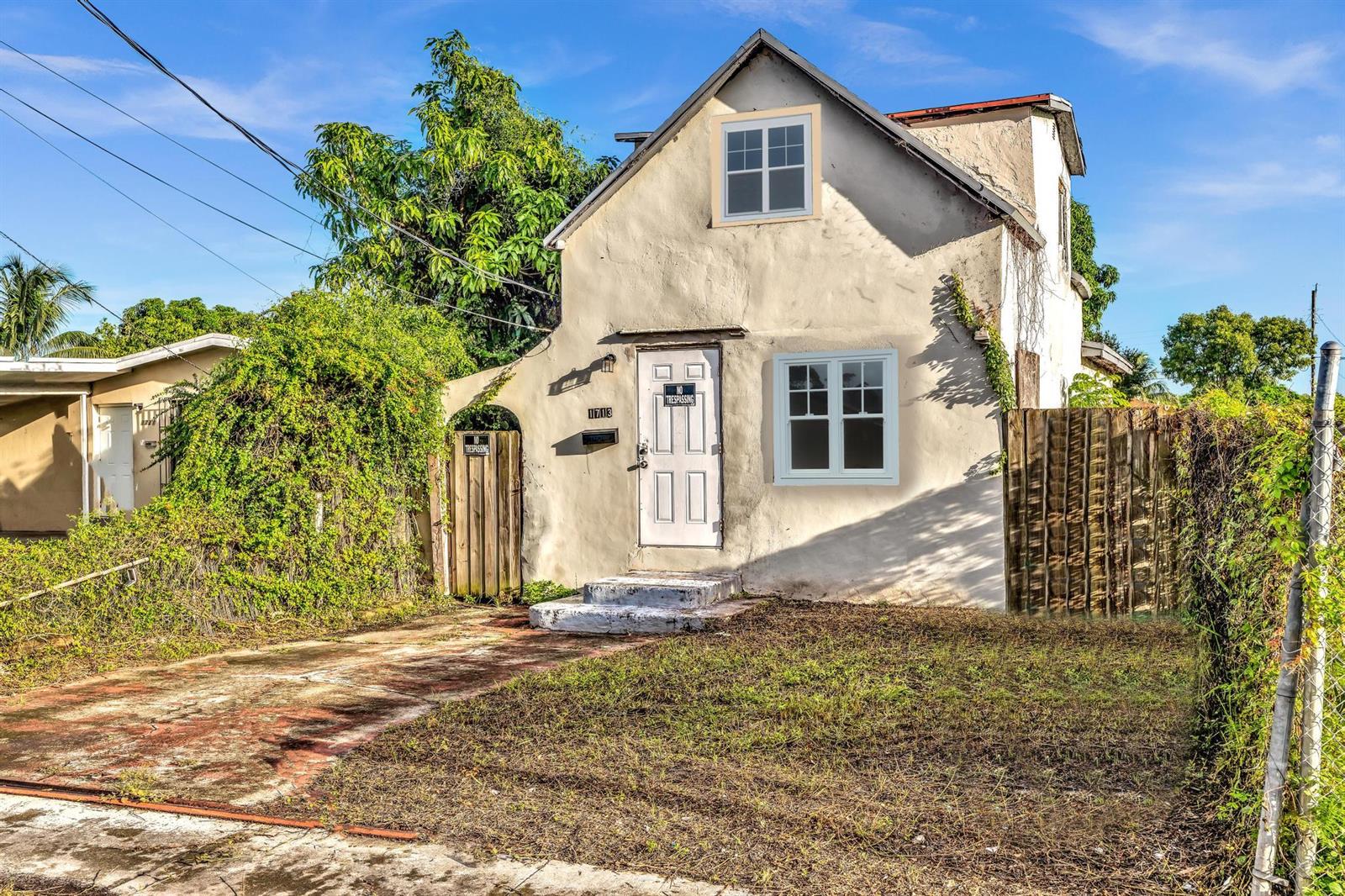 A two-story stucco house with a white front door and a small patch of grass — 1713 NW 76th Terrace, Miami FL 33147, MIAMI, FL