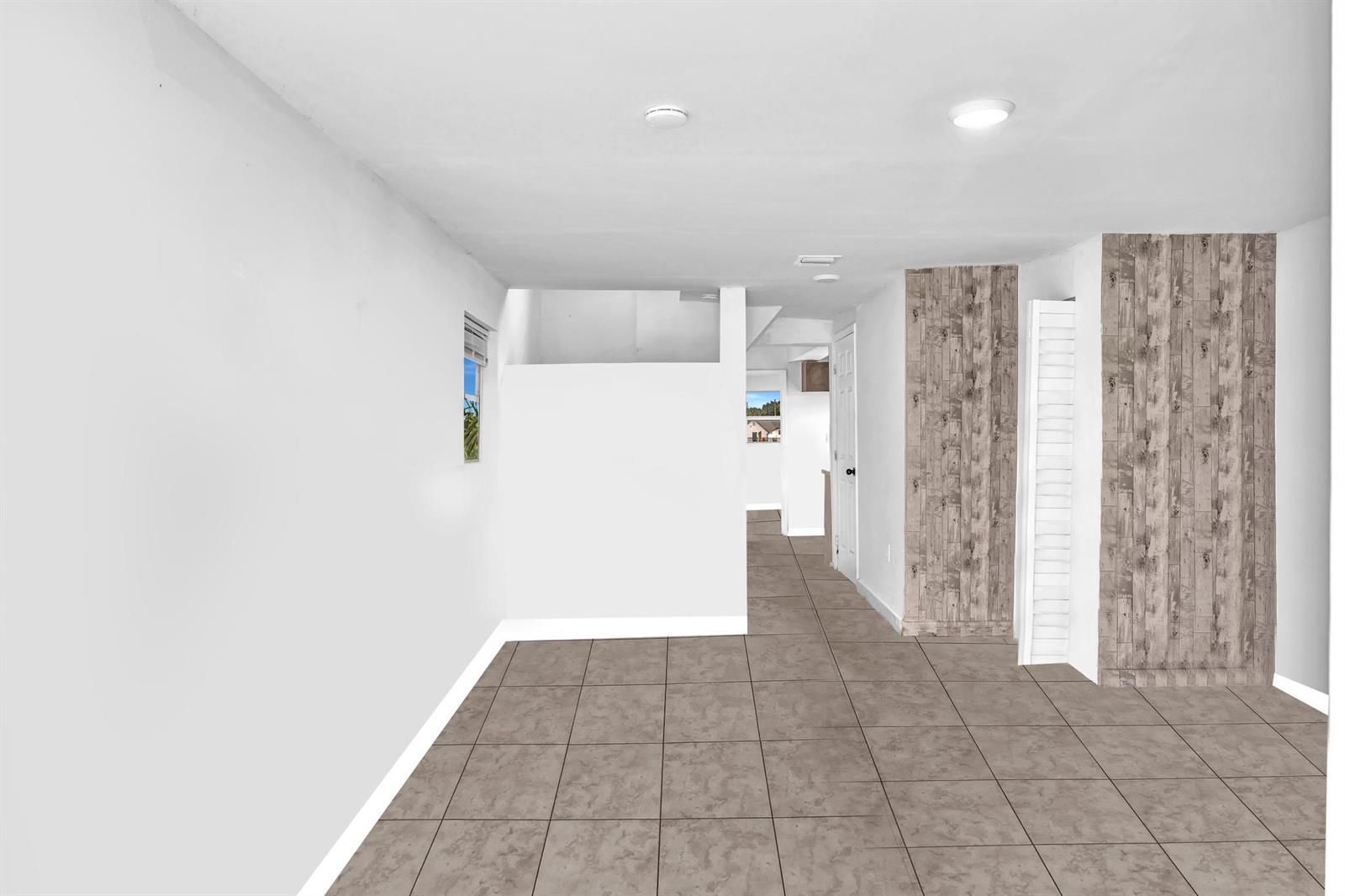 This interior room features white walls, tiled flooring, and two vertical wood-paneled accent walls — 1713 NW 76th Terrace, Miami FL 33147, MIAMI, FL