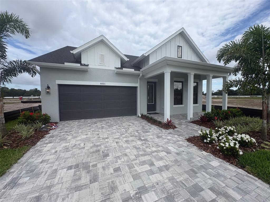 A single-story house with a paved driveway, a two-car garage, and palm trees — 6821 CHLOE COURT, SARASOTA, FL