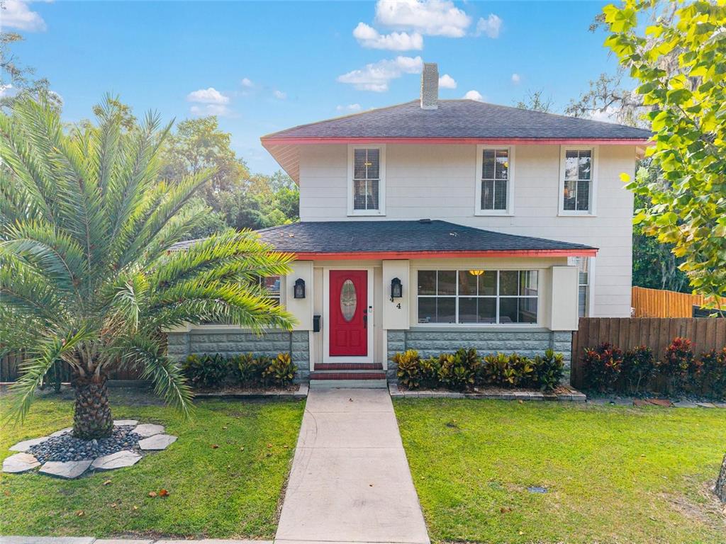 A two-story house with white siding, a red front door, and a palm tree — 44 SE 9TH TERRACE, OCALA, FL