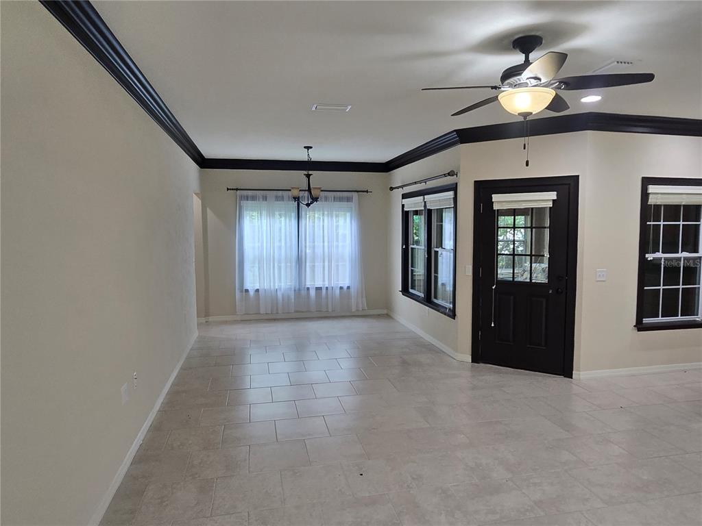 A dining area with tile floors, a ceiling fan, and black crown molding — 19176 NW 228TH STREET, HIGH SPRINGS, FL