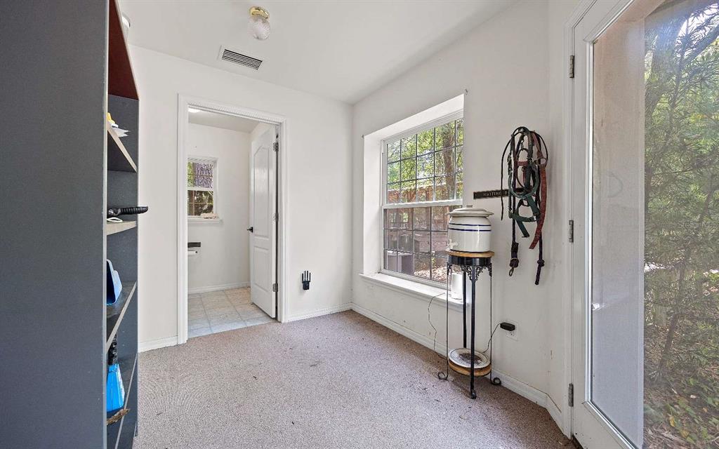 A sparsely furnished room with beige carpet, a window, and a large black metal safe — 2060 NE 100TH ST ROAD, BRANFORD, FL