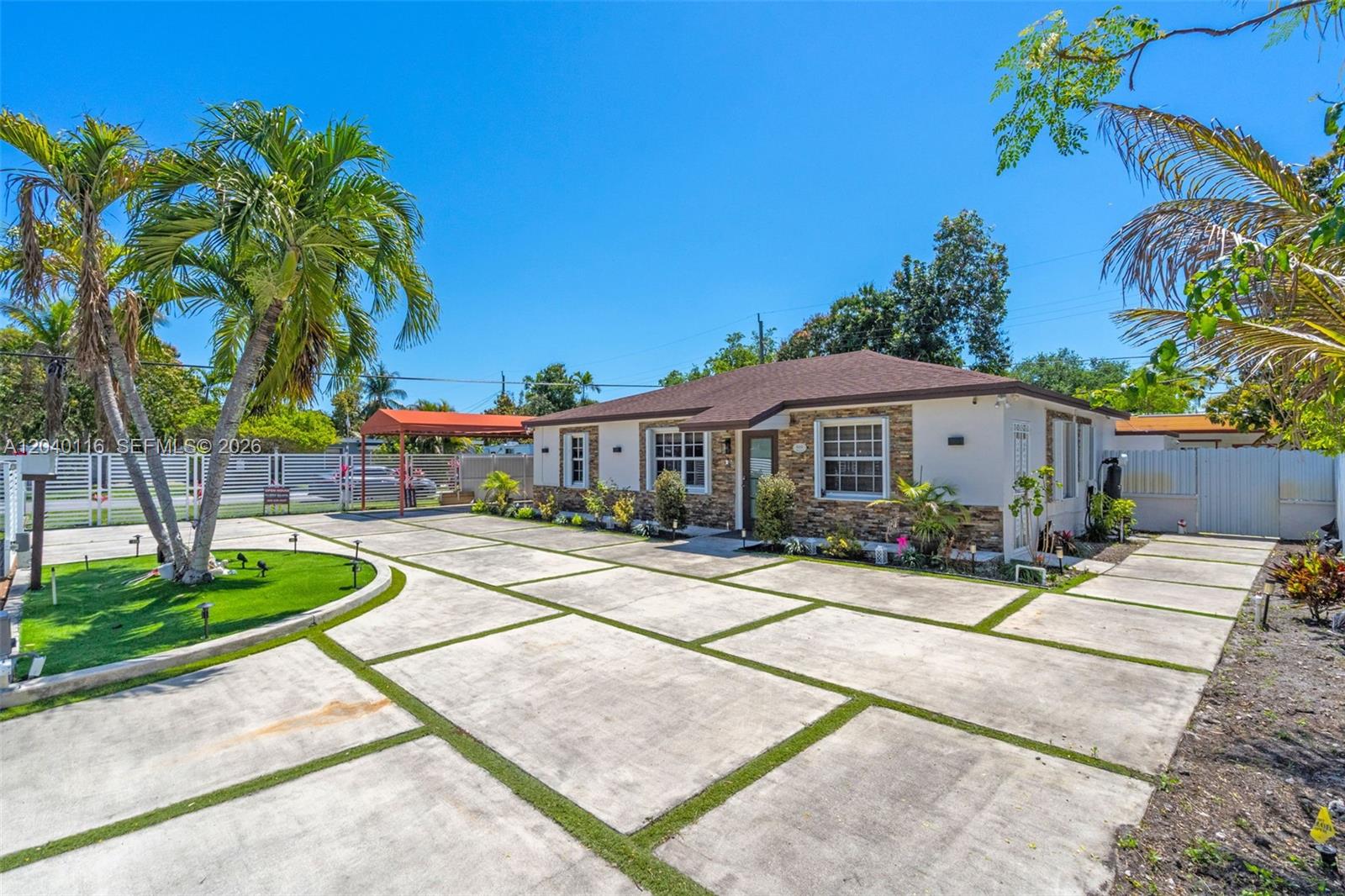 A single-story house with a stone facade and a large concrete driveway with grass strips — 302 NW 100th St, Miami FL 33150, MIAMI, FL