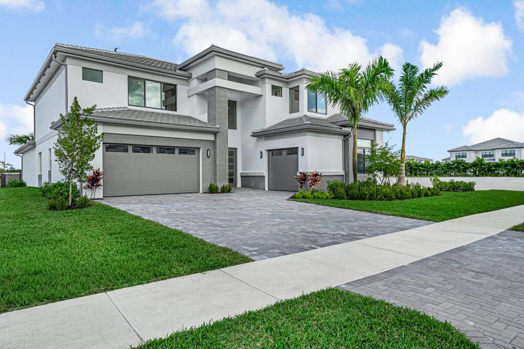 A two-story modern house with a gray exterior, two garage doors, and a paved driveway — 13531 Nesting Pines Way, Palm Beach Gardens FL 33412, PALM BEACH GARDENS, FL